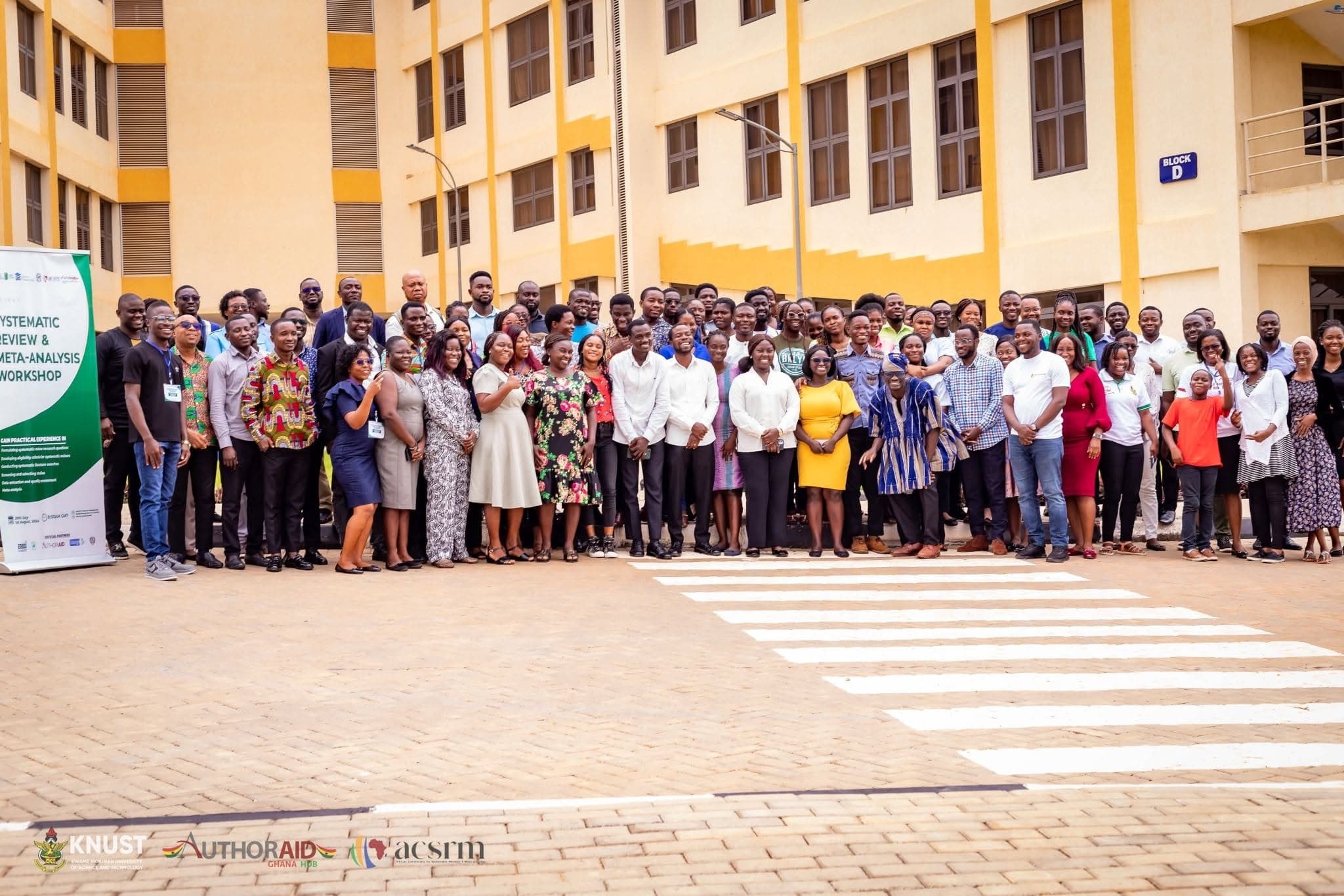A large group of researchers gathered outside a workshop venue.