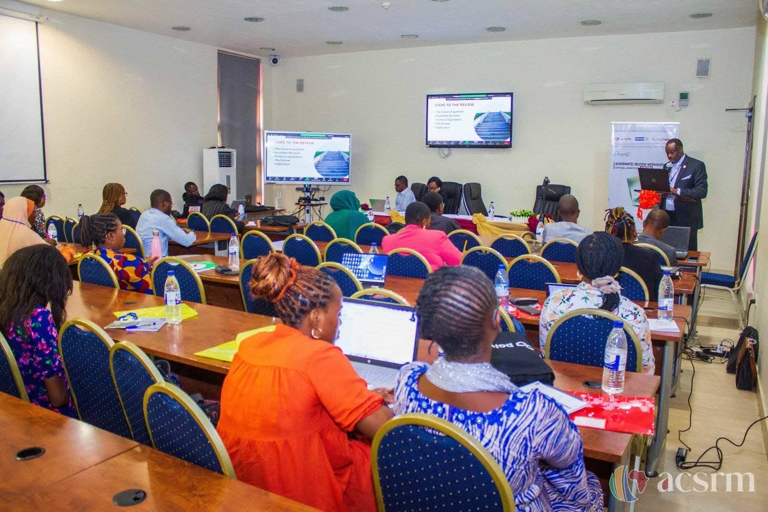 Participants listening to a presentation during an evidence-synthesis workshop.
